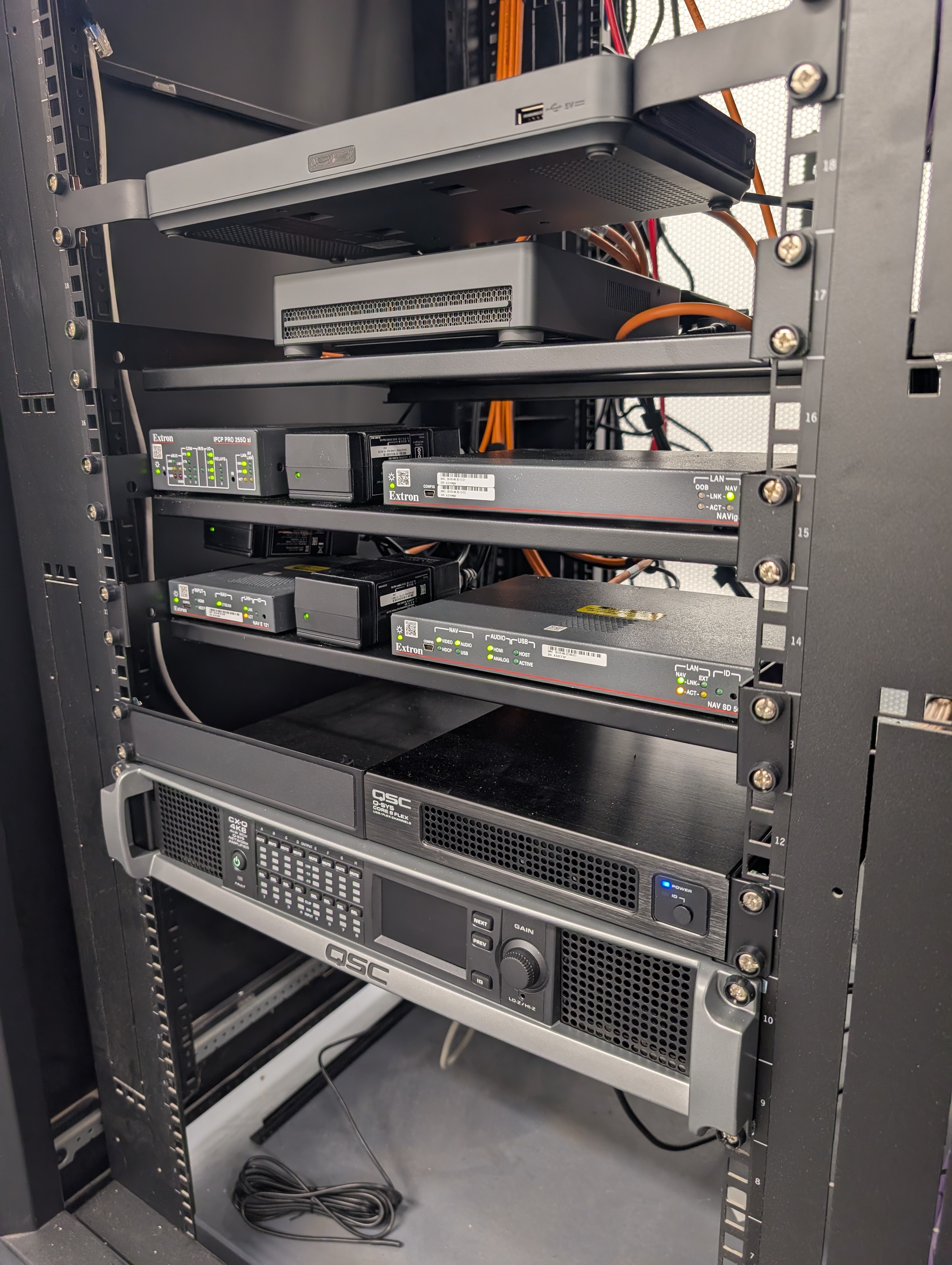 Equipment rack with Extron NAV, Q-SYS Core, and QSC amplification